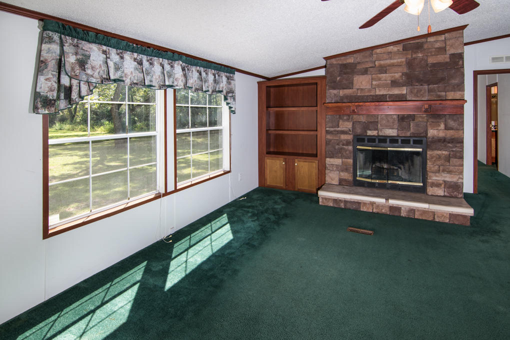 423 Tedder Road East DeFuniak Springs, FL 32433 - Photo 4 of 29 a living room with a fireplace and a large window