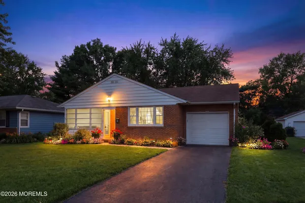 a front view of a house with a yard and trees