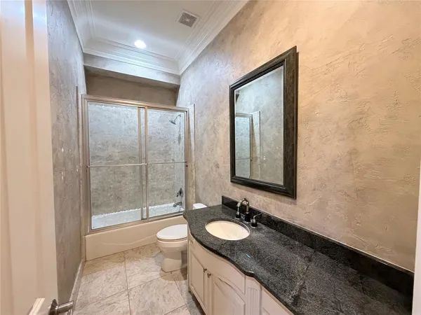 a bathroom with a granite countertop sink toilet and shower