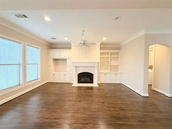 wooden floor fireplace and windows in an empty room