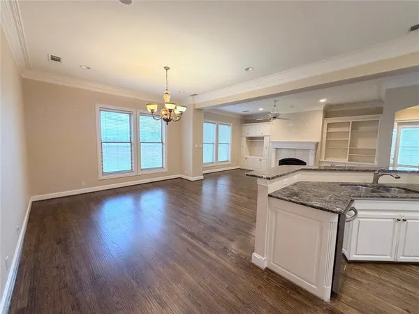 a kitchen with granite countertop wooden floors and wide window