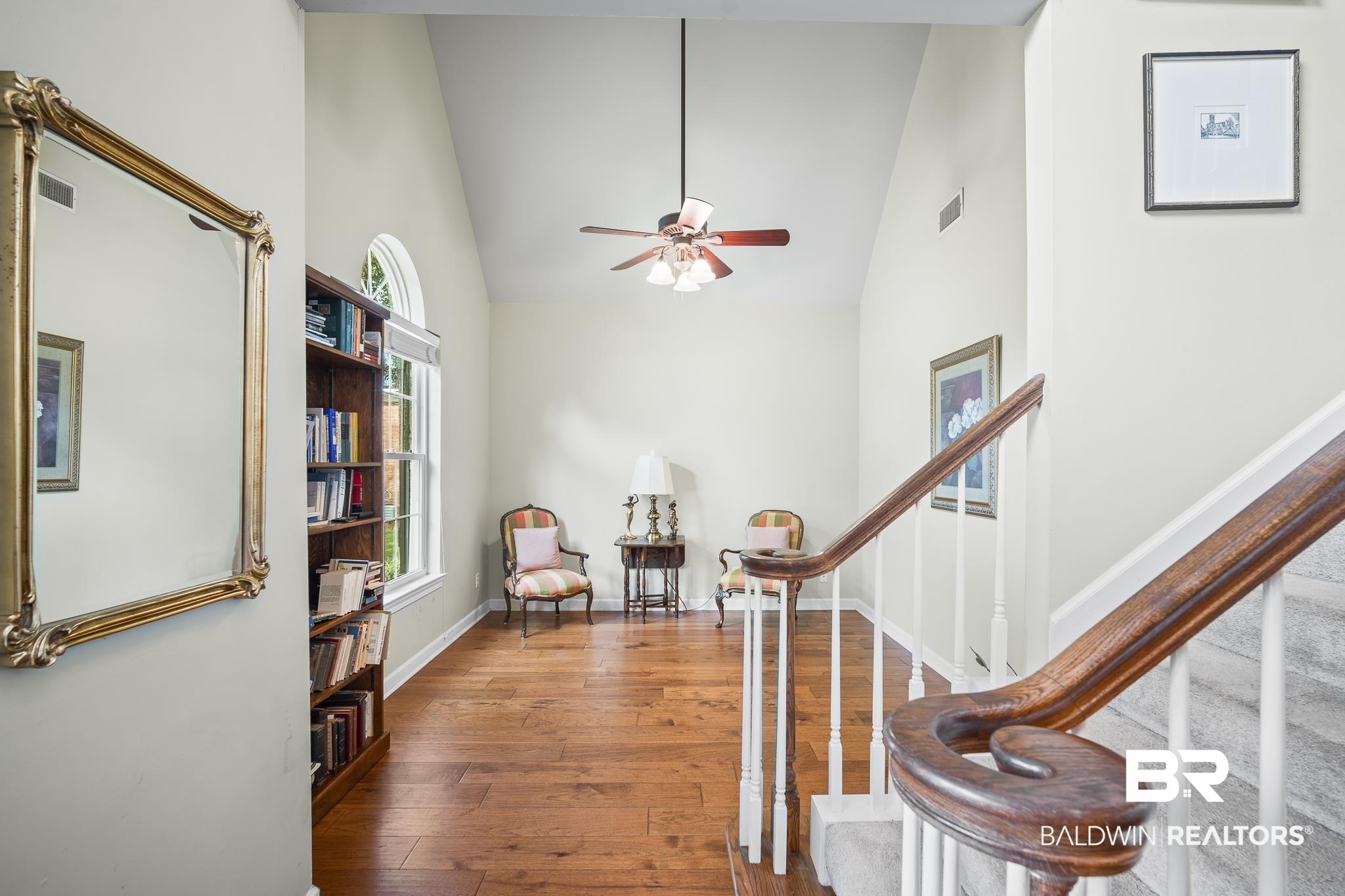 Entrance foyer with high vaulted ceiling, hardwood / wood-style floors, stairway, and a ceiling fan