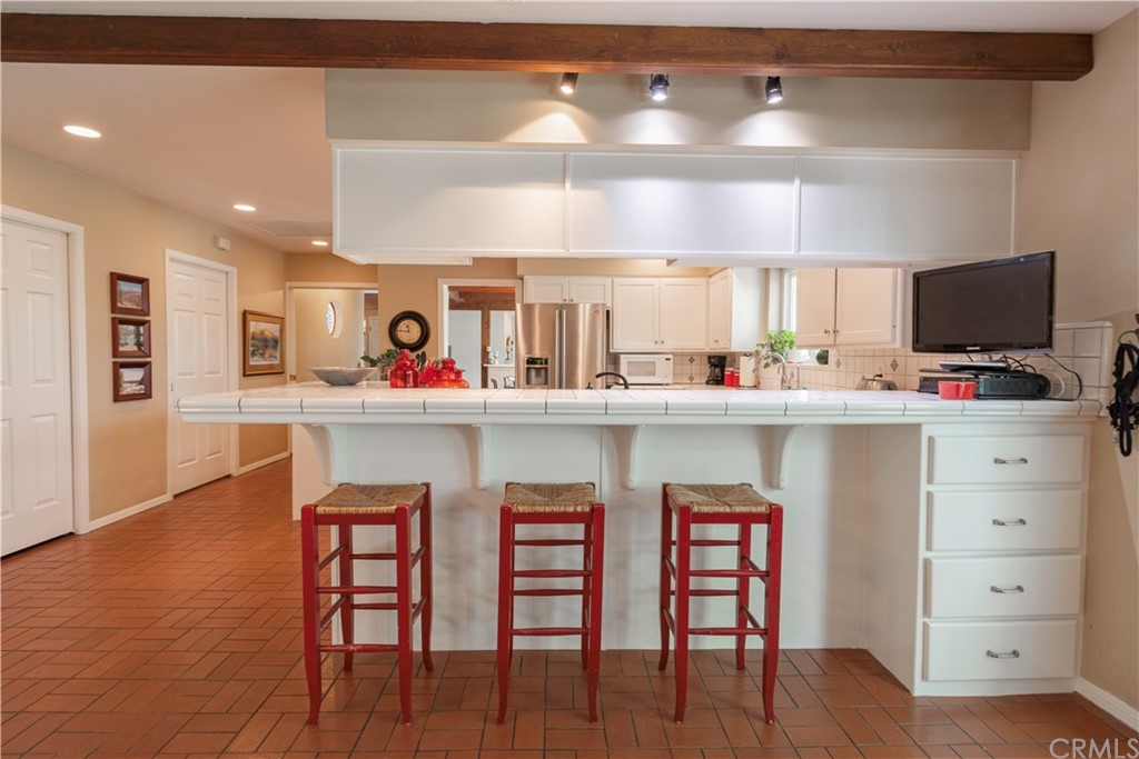 2755 Ardilla Road Atascadero, CA 93422 - Photo 13 of 42 a kitchen with stainless steel appliances kitchen island granite countertop a table chairs and a refrigerator