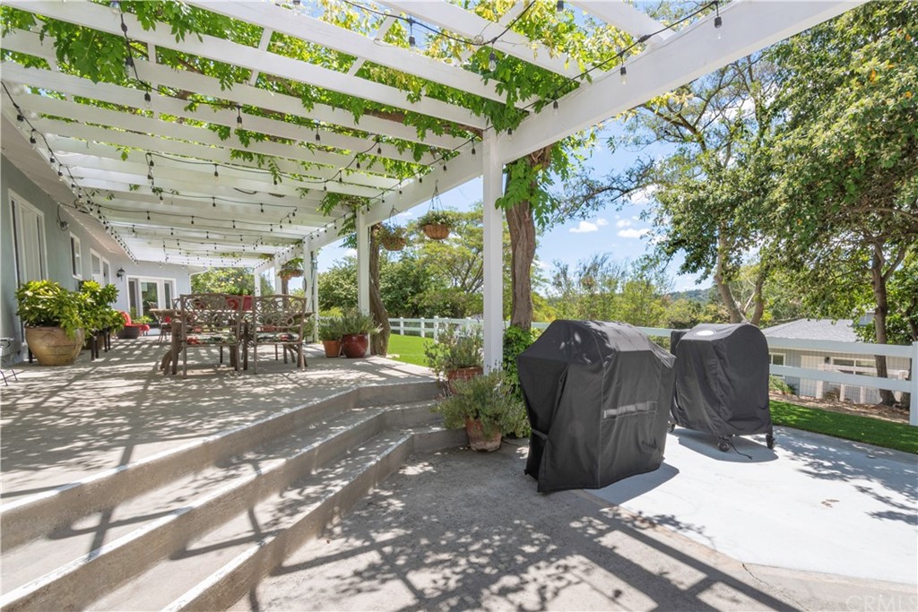 2755 Ardilla Road Atascadero, CA 93422 - Photo 27 of 42 a view of a patio with table and chairs potted plants and large tree
