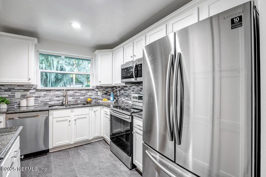 1050 Glynlea Road Jacksonville, FL 32216 - Photo 12 of 38 a kitchen with a refrigerator sink and microwave