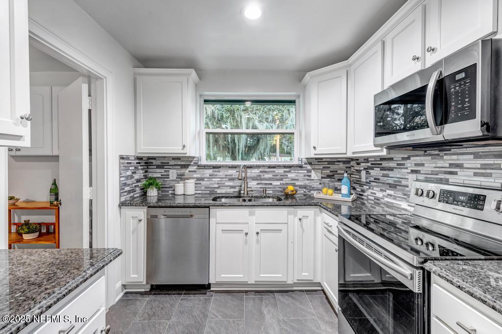 1050 Glynlea Road Jacksonville, FL 32216 - Photo 13 of 38 a kitchen with stainless steel appliances granite countertop a sink and a stove
