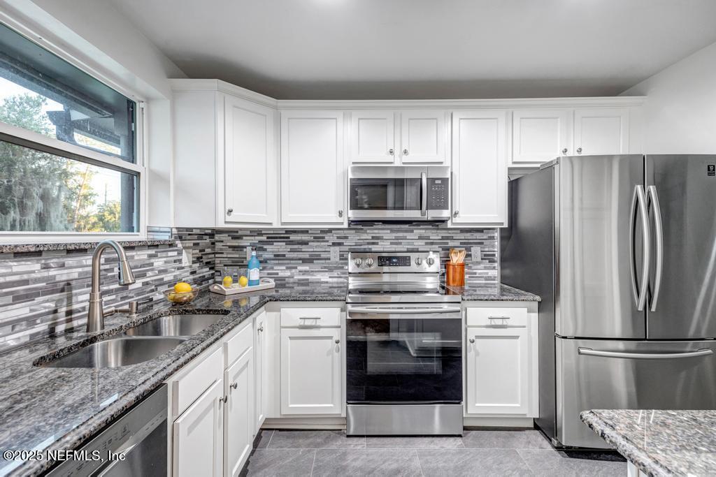 1050 Glynlea Road Jacksonville, FL 32216 - Photo 14 of 38 a kitchen with stainless steel appliances a refrigerator sink and microwave