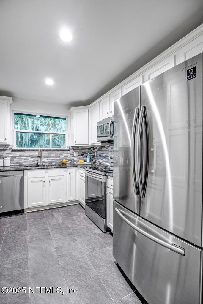 1050 Glynlea Road Jacksonville, FL 32216 - Photo 15 of 38 a kitchen with stainless steel appliances a refrigerator sink and cabinets