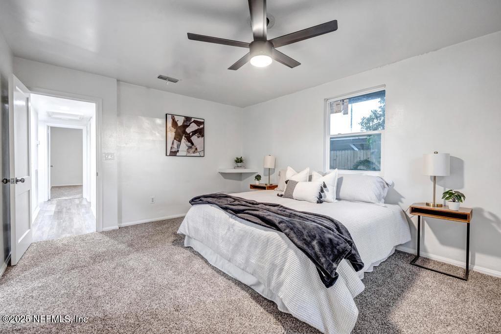 1050 Glynlea Road Jacksonville, FL 32216 - Photo 22 of 38 a spacious bedroom with a bed and a chandelier