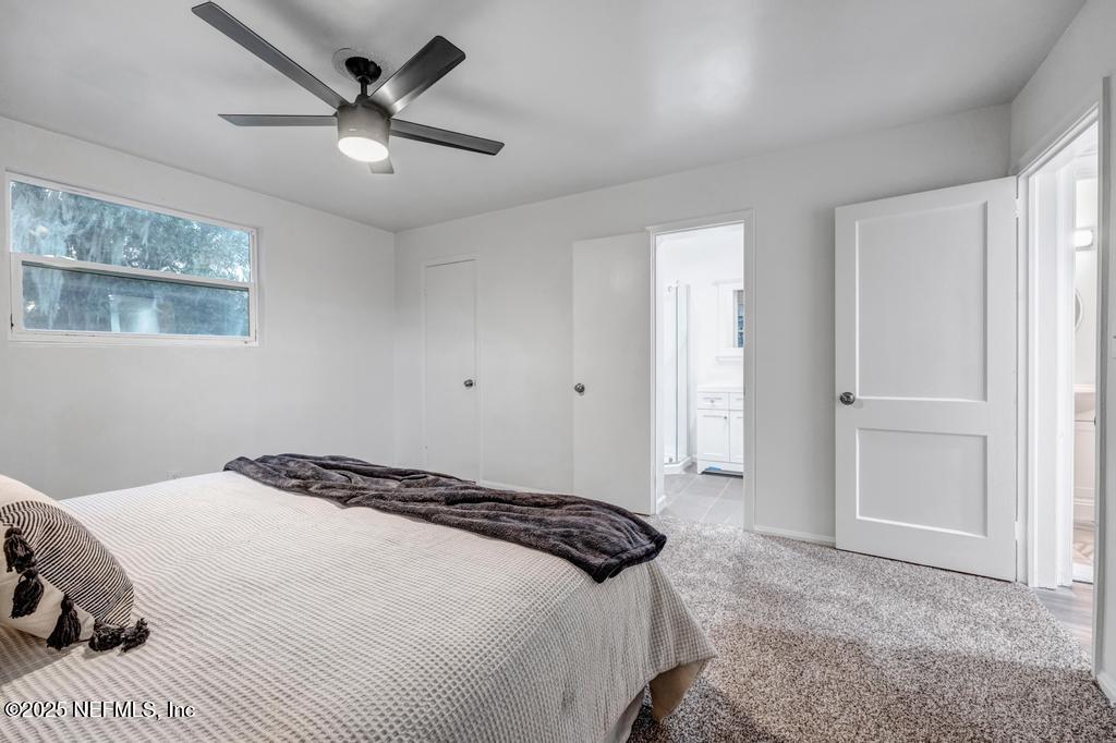 1050 Glynlea Road Jacksonville, FL 32216 - Photo 23 of 38 a bedroom with a large bed and a chandelier