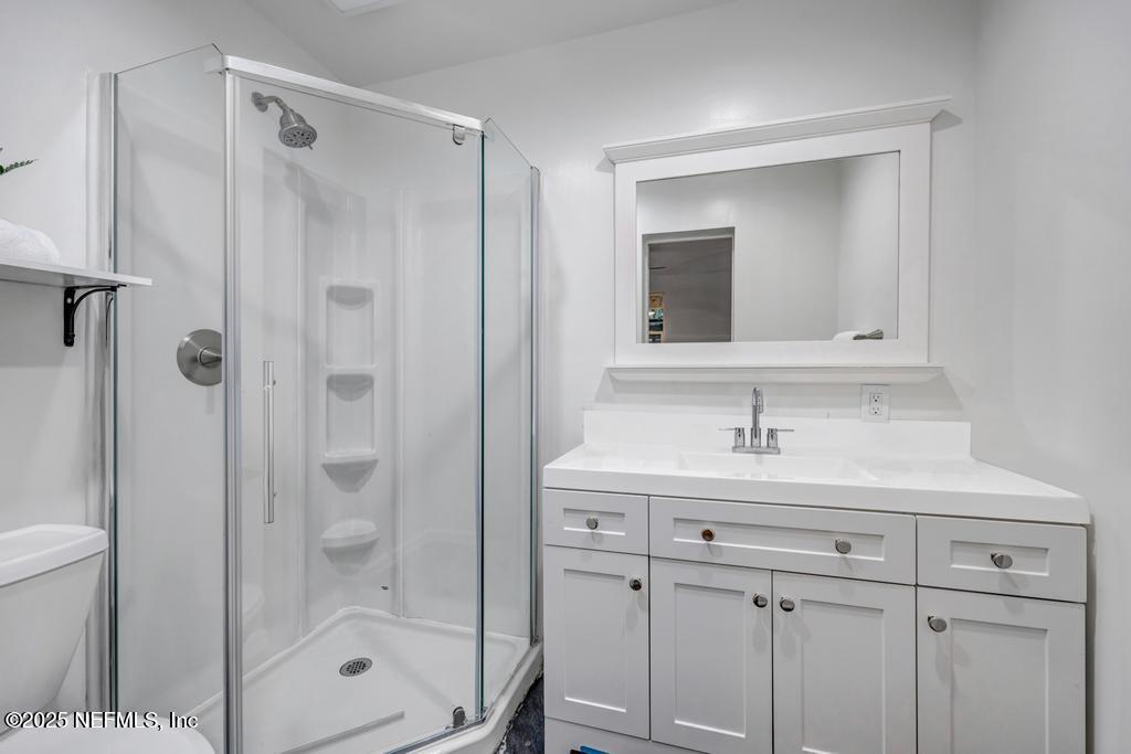 1050 Glynlea Road Jacksonville, FL 32216 - Photo 24 of 38 a bathroom with a shower sink vanity and mirror
