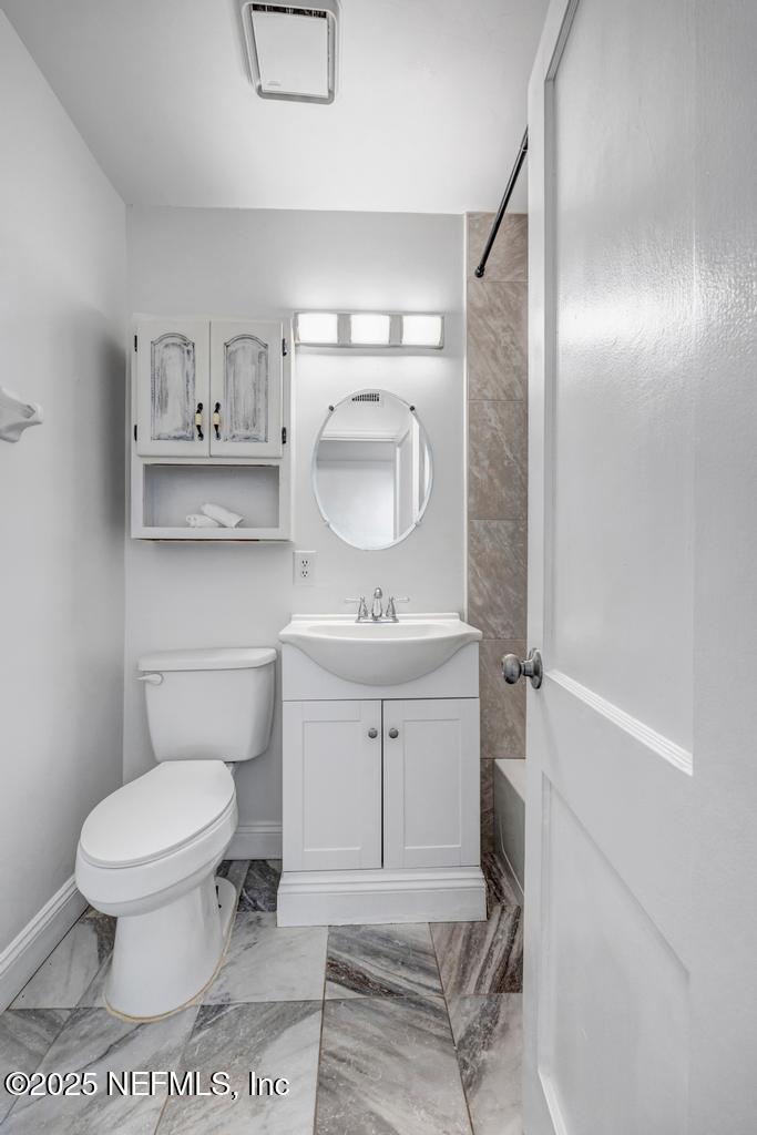 1050 Glynlea Road Jacksonville, FL 32216 - Photo 26 of 38 a bathroom with a sink a toilet and a mirror