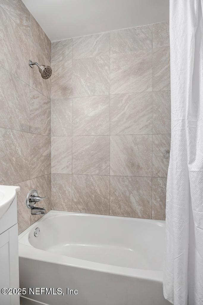 1050 Glynlea Road Jacksonville, FL 32216 - Photo 27 of 38 a bath tub sitting next to a white sink and vanity