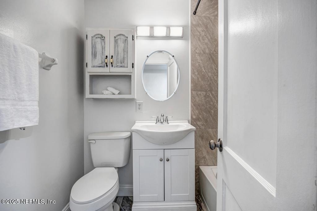 1050 Glynlea Road Jacksonville, FL 32216 - Photo 28 of 38 a bathroom with a toilet a sink and a mirror