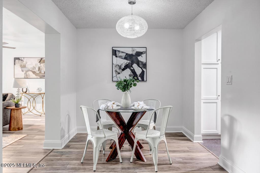 1050 Glynlea Road Jacksonville, FL 32216 - Photo 10 of 38 a view of a dining room with furniture wooden floor and a chandelier