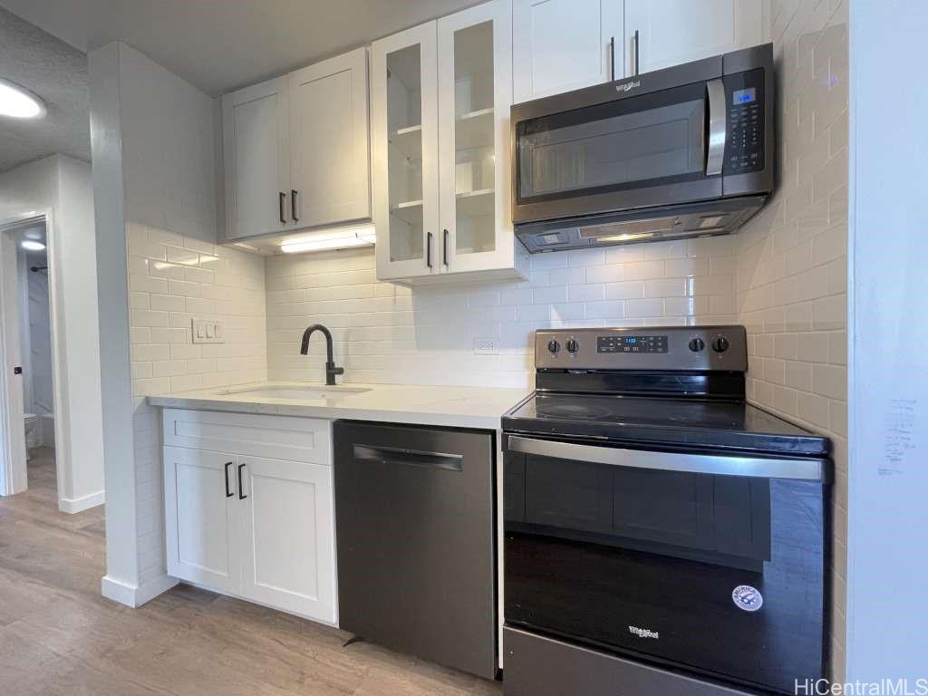 a kitchen with stainless steel appliances a stove microwave and sink
