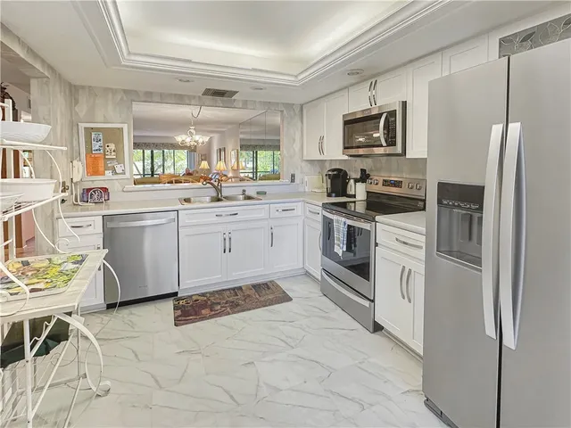 a kitchen with stainless steel appliances granite countertop a stove top oven a sink dishwasher a refrigerator and a microwave