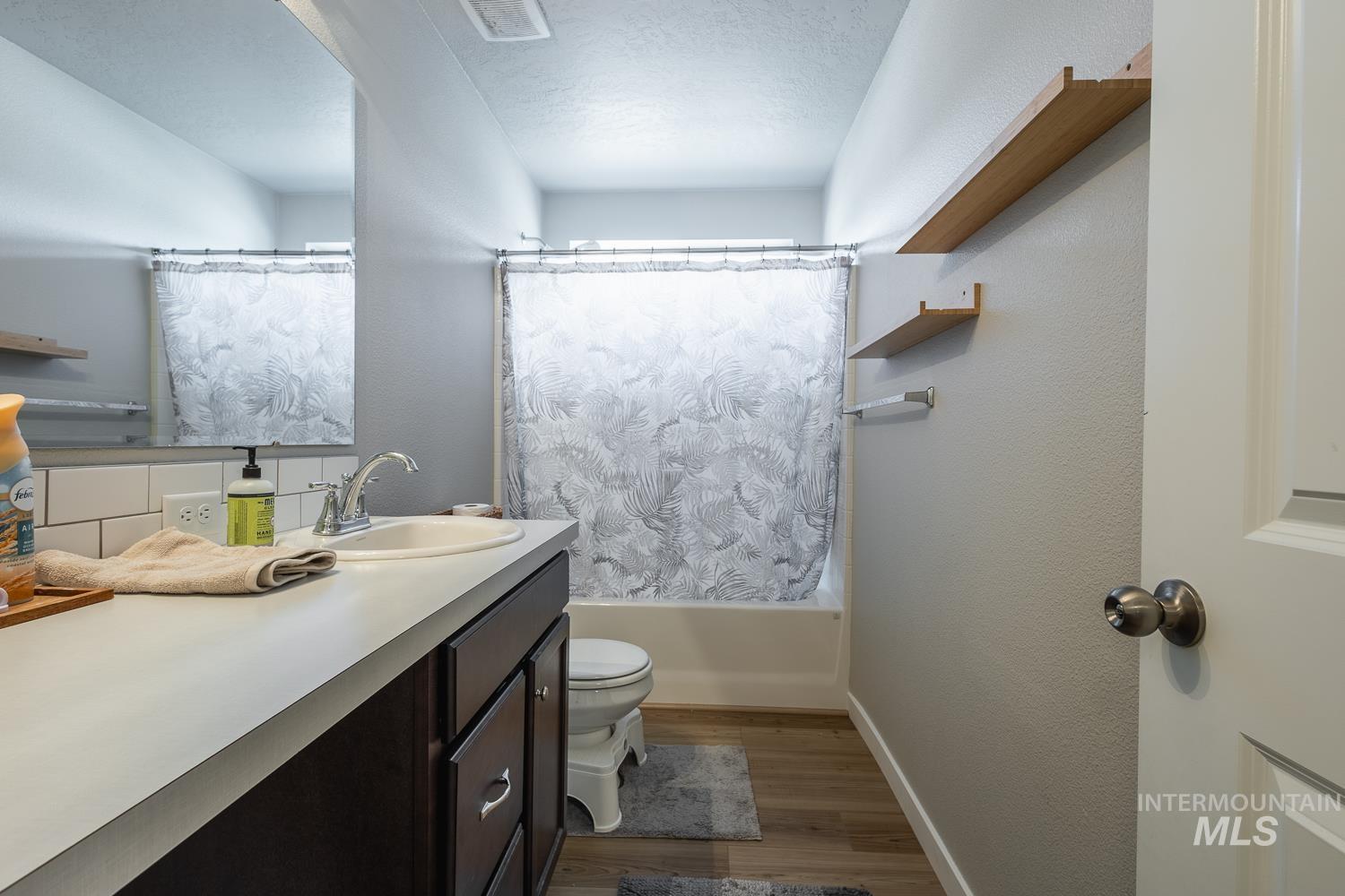 12623 Shadow Peak Street Caldwell, ID 83607 - Photo 38 of 50 Bathroom featuring a single vanity with a white countertop, dark wood-finish cabinetry, and a subway tile backsplash