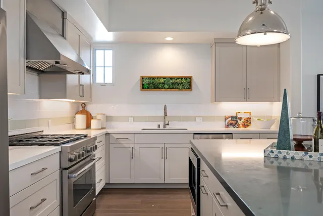 a kitchen with stainless steel appliances a sink stove and cabinets