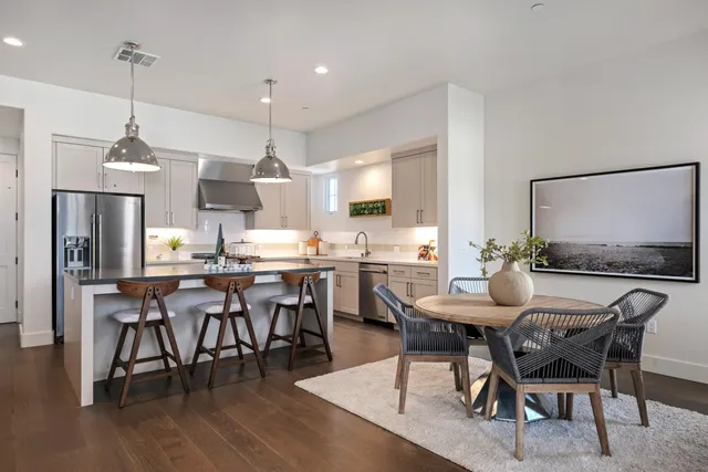 a dining room with stainless steel appliances kitchen island granite countertop a dining table chairs and view kitchen