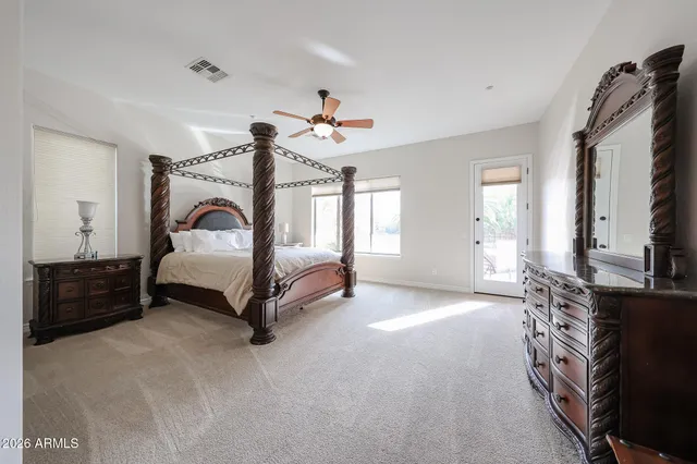 a bathroom with a granite countertop double vanity sink a mirror and a shower