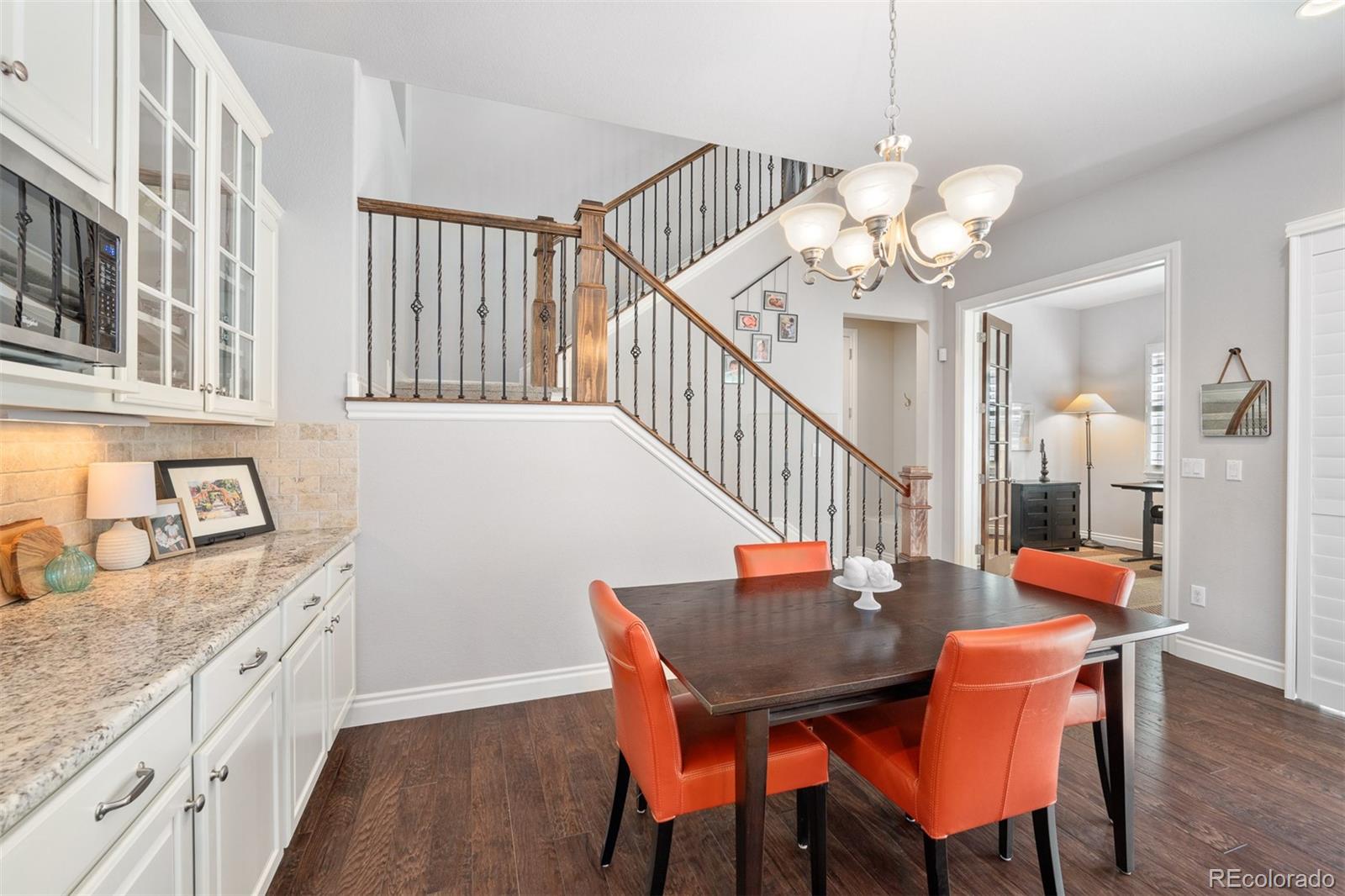 10140 RidgeGate Circle Lone Tree, CO 80124 - Photo 11 of 32 a view of a dining room with furniture a chandelier and wooden floor