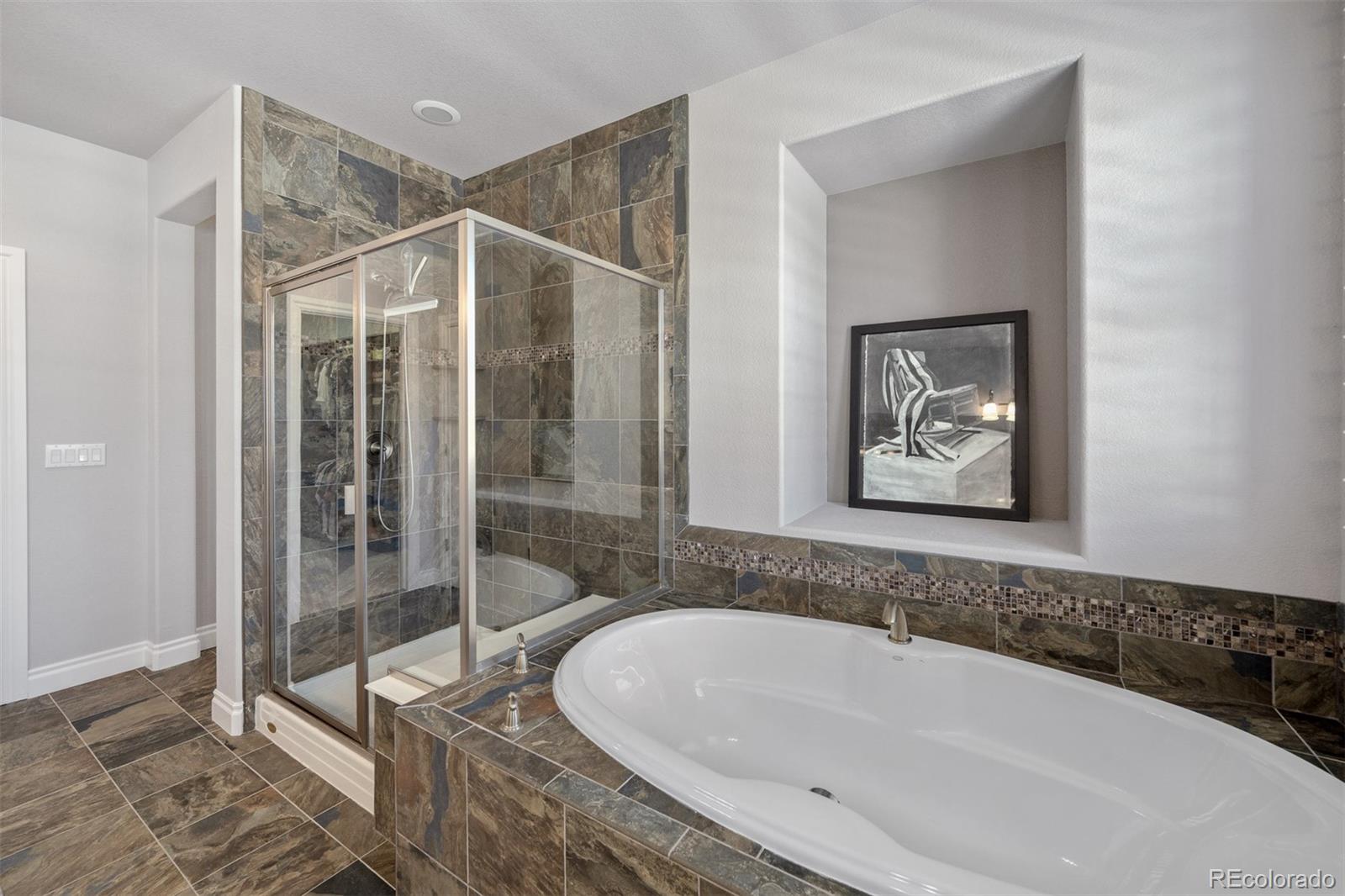 10140 RidgeGate Circle Lone Tree, CO 80124 - Photo 27 of 32 a bathroom with a bathtub and a shower