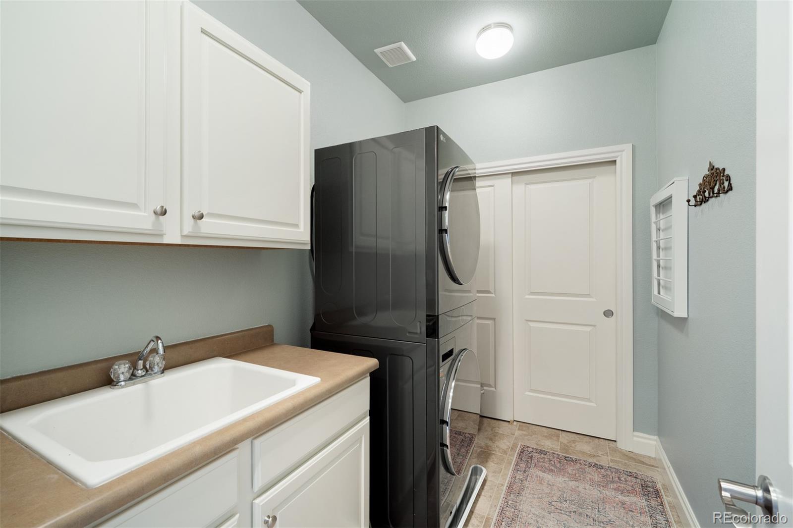 10140 RidgeGate Circle Lone Tree, CO 80124 - Photo 32 of 32 a bathroom with a sink and a washing machine