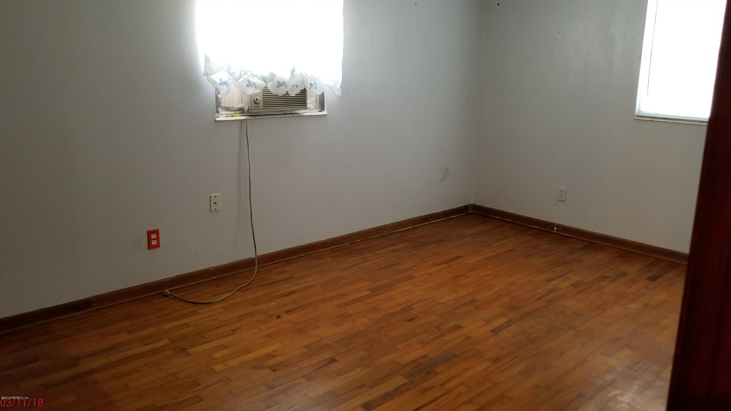 405 Skate Road Atlantic Beach, FL 32233 - Photo 9 of 15 an empty room with wooden floor and windows