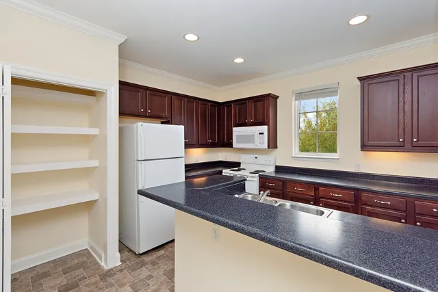 a kitchen with kitchen island granite countertop a sink stove and refrigerator