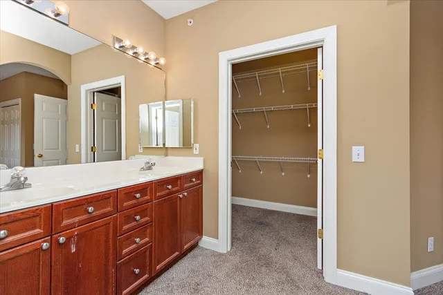 a bath room with a sink and a large mirror
