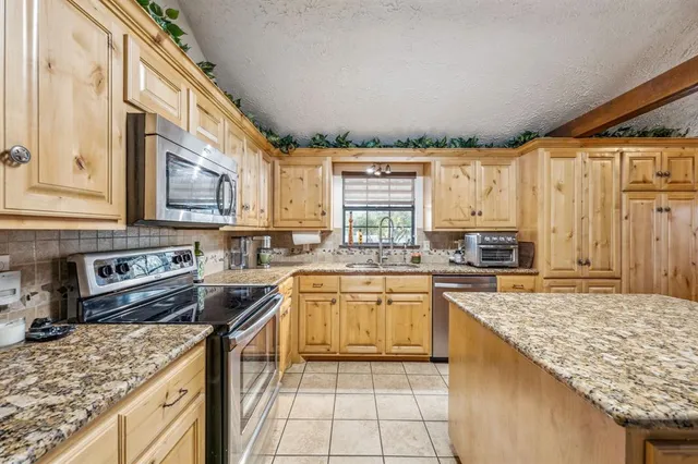 a kitchen with stainless steel appliances granite countertop a stove sink and cabinets
