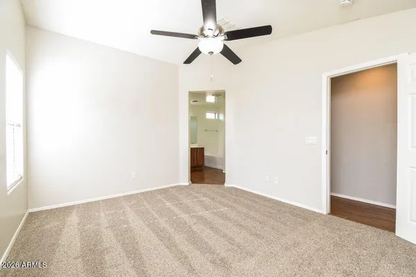 a view of an empty room with chandelier fan
