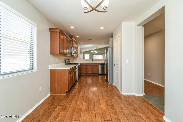 a large kitchen with wooden floor and stainless steel appliances