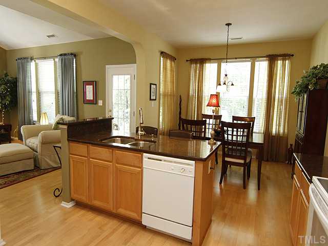 8512 Slabstone Court Raleigh, NC 27613 - Photo 8 of 21 a kitchen with stainless steel appliances granite countertop sink stove and wooden floor