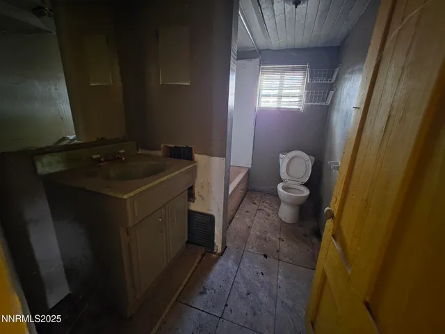a bathroom with a granite countertop sink and a toilet
