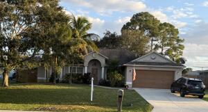 a front view of a house with a garden and trees