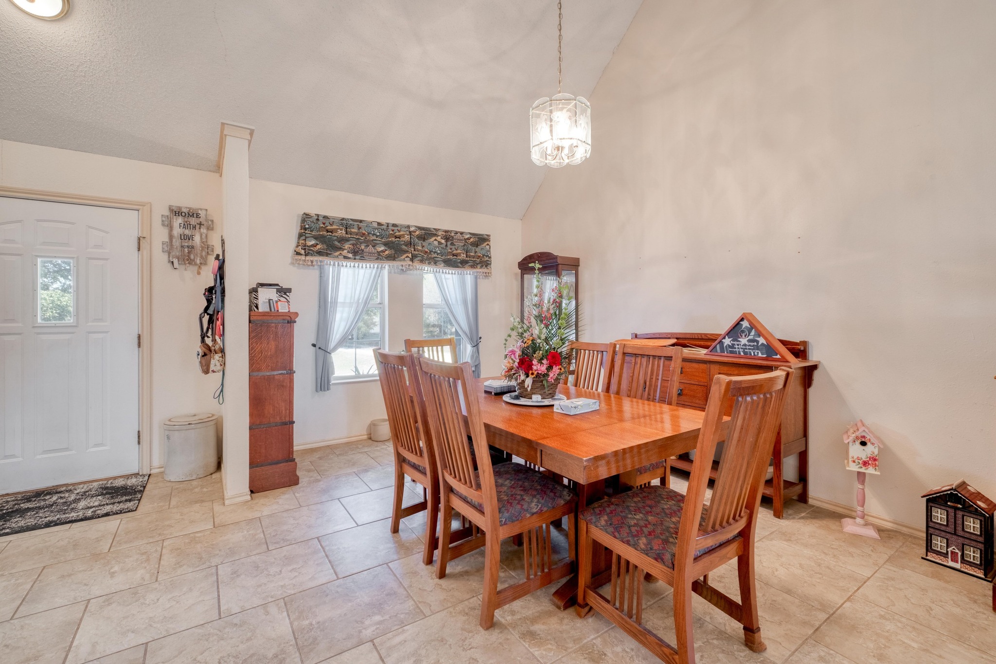 153 Pleasant Grove Road Elgin, TX 78621 - Photo 11 of 34 Dining area with high vaulted ceiling and a chandelier