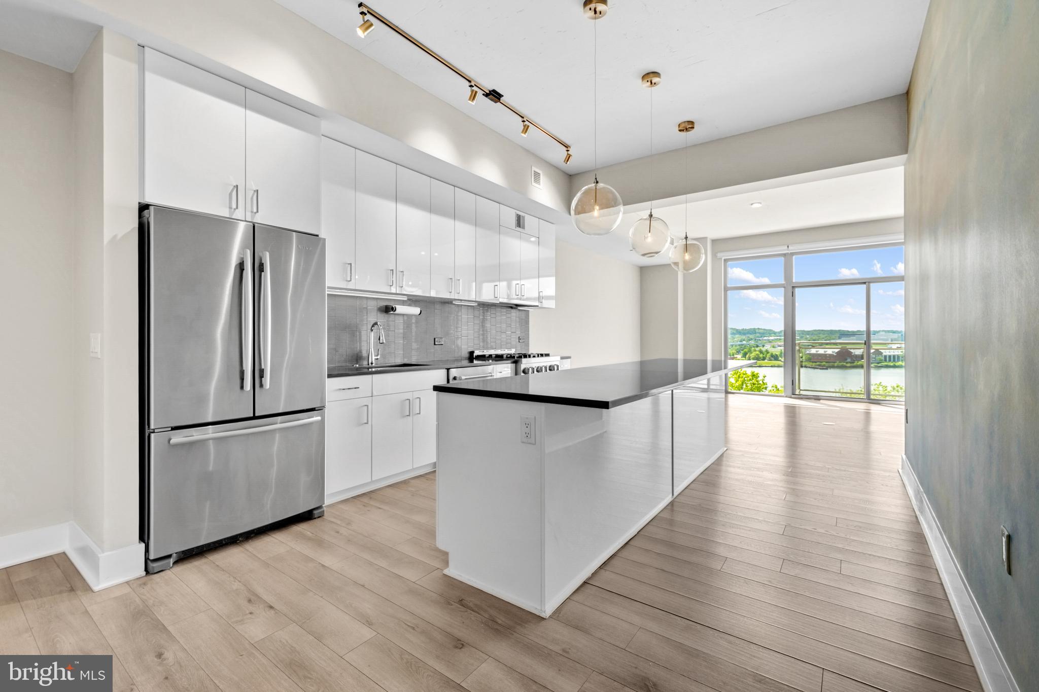88 V Street Southwest, Unit 808 Washington, DC 20024 - Photo 12 of 47 a kitchen with kitchen island wooden floors appliances and center island