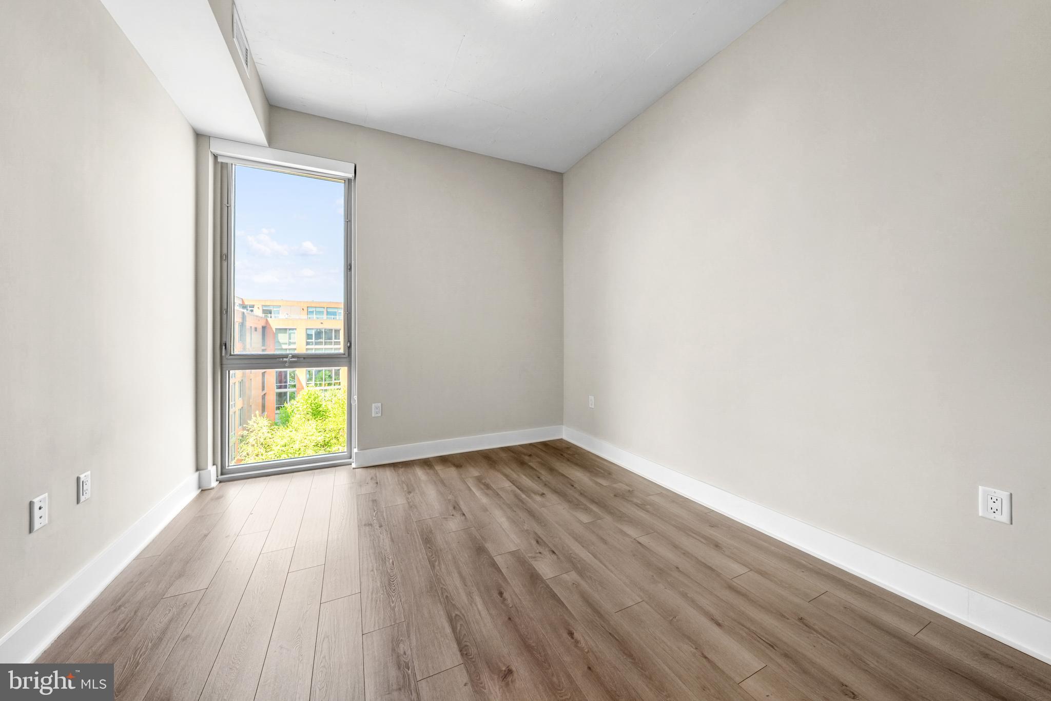 88 V Street Southwest, Unit 808 Washington, DC 20024 - Photo 20 of 47 an empty room with wooden floor and a window