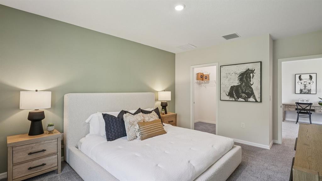 32516 Welling Blade Loop Wesley Chapel, FL 33545 - Photo 19 of 39 a bedroom with a bed and a lamp on dresser