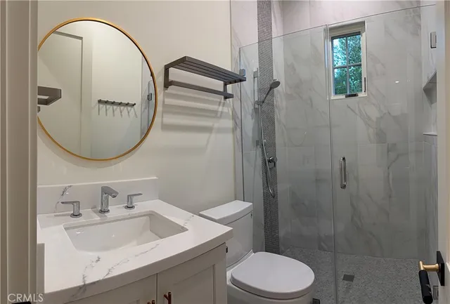 a bathroom with a sink a toilet and a mirror