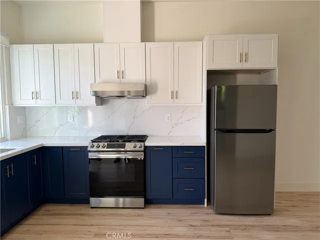 a kitchen with a refrigerator and a stove