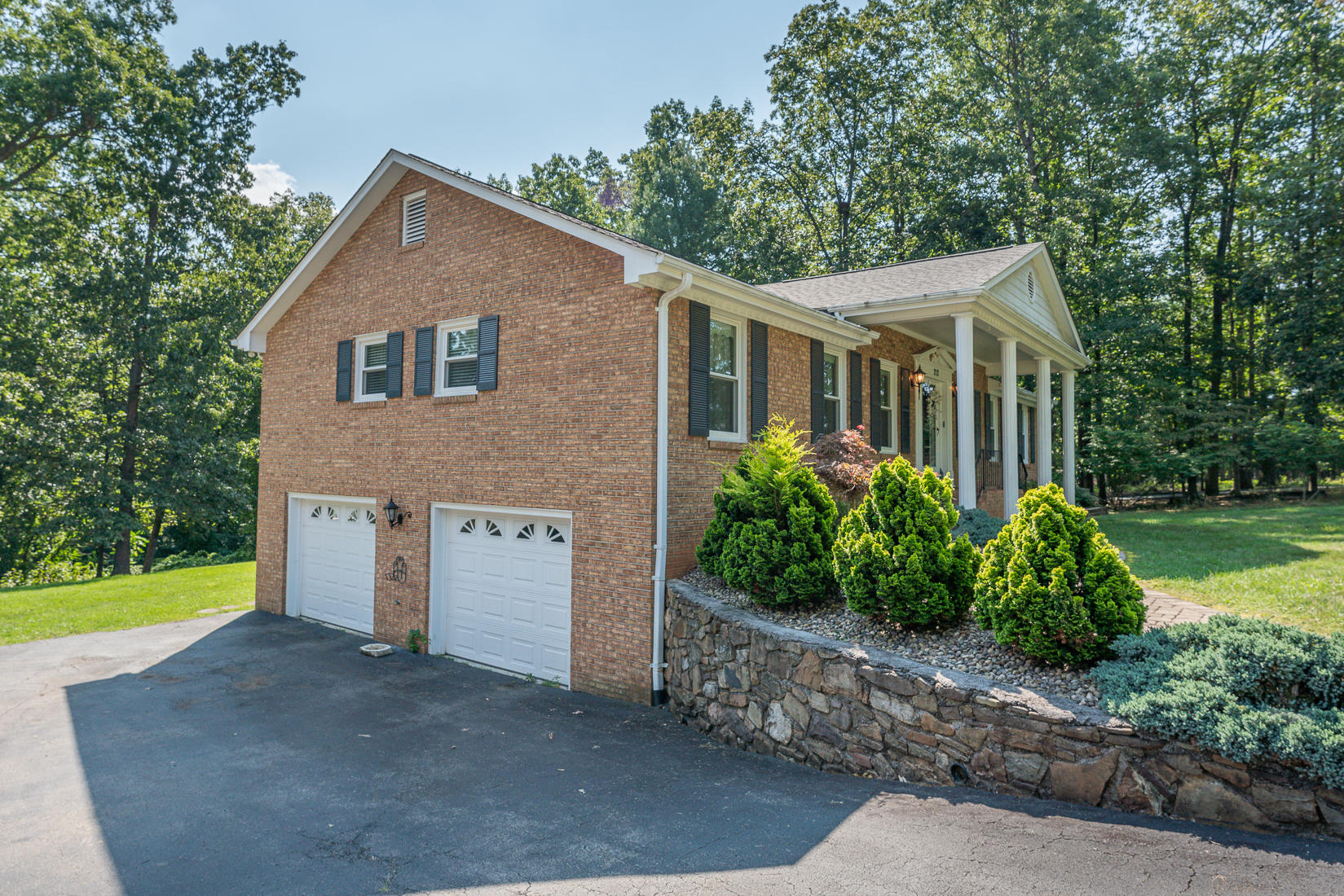 212 Queen Regent Court Blue Ridge, VA 24064 - Photo 3 of 55 a view of a yard in front of a house with plants and large tree