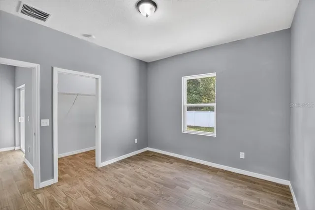 a view of empty room with wooden floor