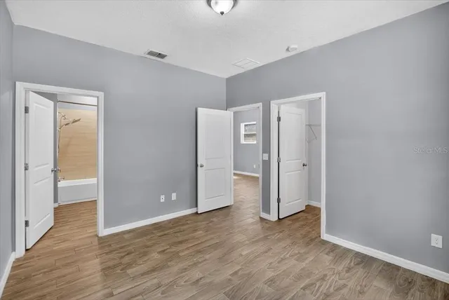 a view of an empty room with wooden floor