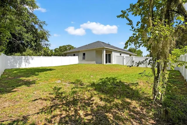 a view of backyard of house with green space