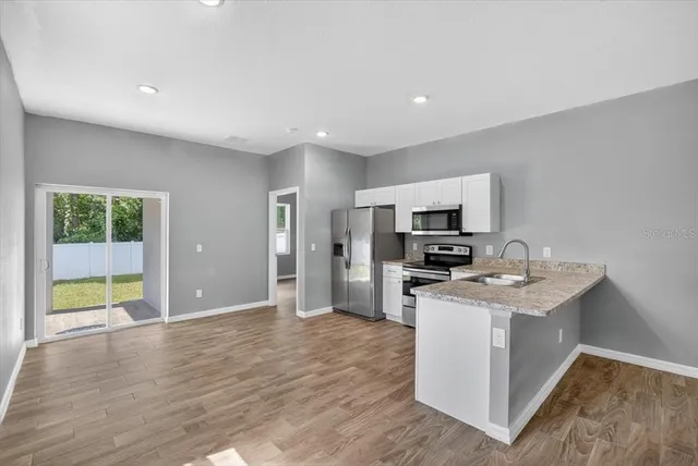 a view of a kitchen with a sink microwave and refrigerator