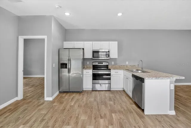 a kitchen with a white cabinets and stainless steel appliances