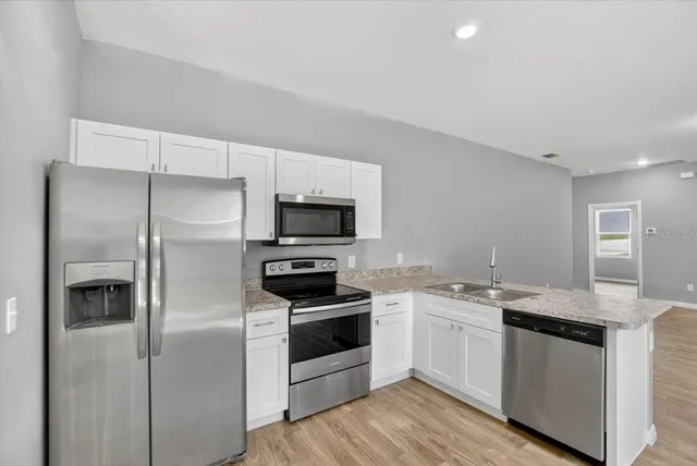 a kitchen with stainless steel appliances granite countertop a stove and a microwave